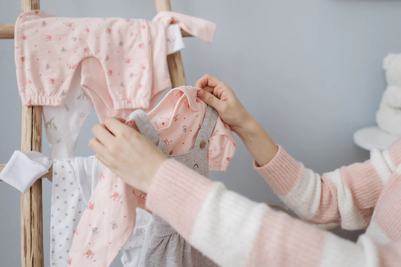 Vêtements de bébé fille suspendus sur un portant dans une chambre d'enfant