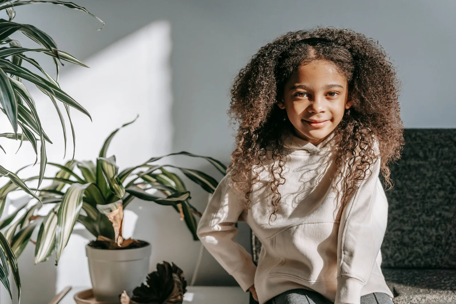Petite fille aux cheveux bouclés, visage dégagé pour une demi-couronne torsadée