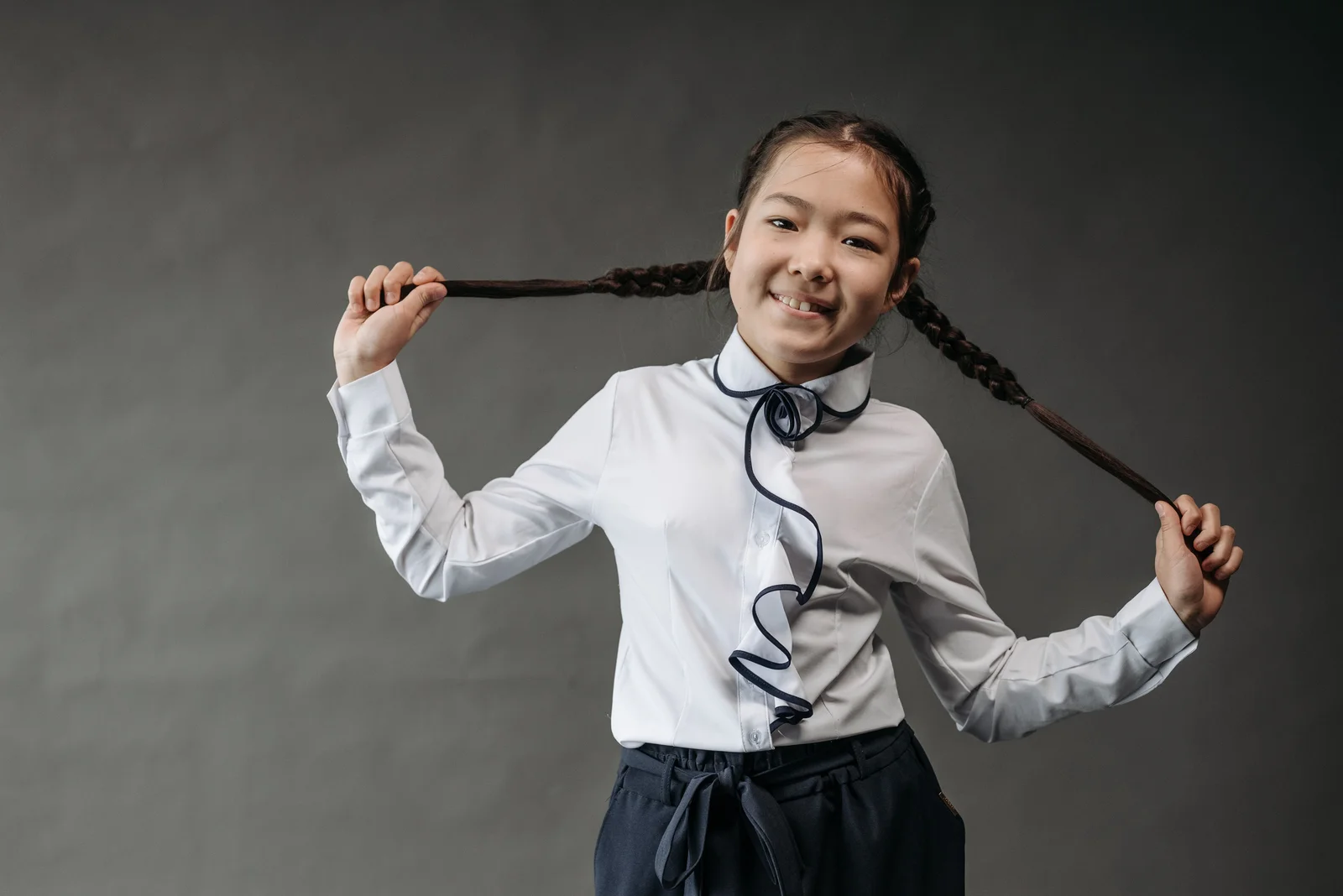 Natte classique à trois brins sur les cheveux longs d'une fillette